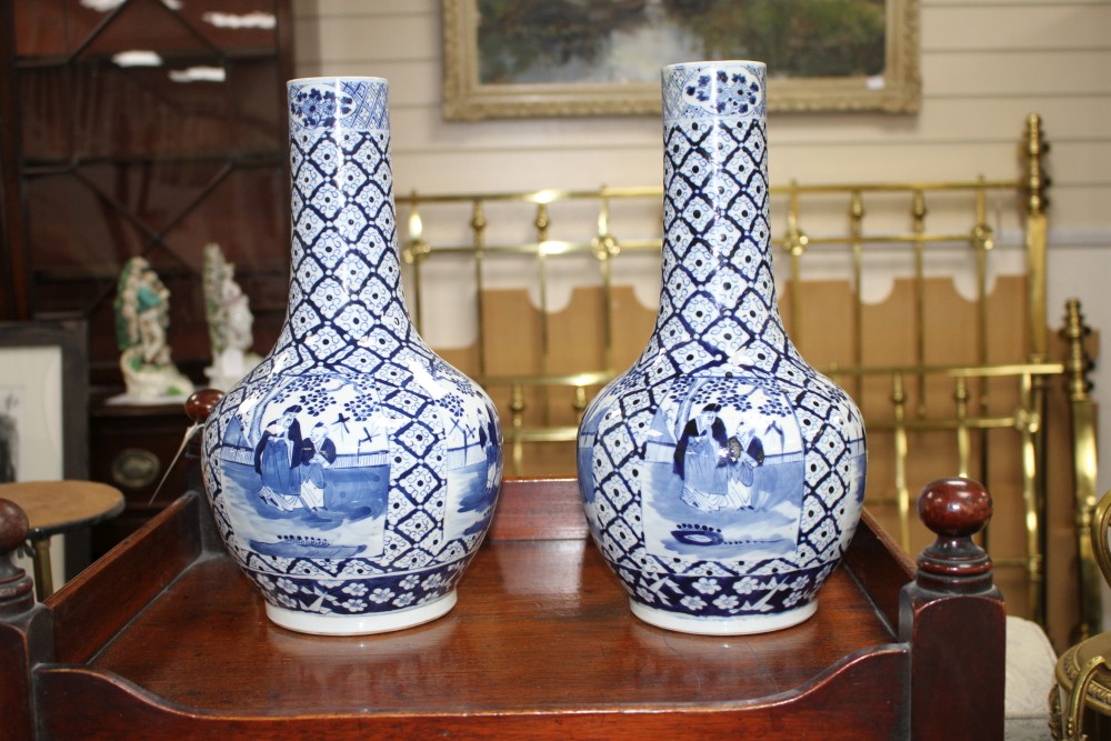 A pair of 19th century Chinese blue and white vases, decorated with panels of figures in gardens, four character marks, height 34.5cm